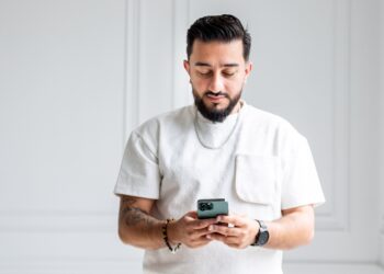 Ali M Saleh with a white shirt on his phone