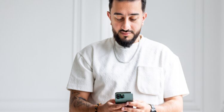 Ali M Saleh with a white shirt on his phone