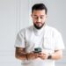 Ali M Saleh with a white shirt on his phone