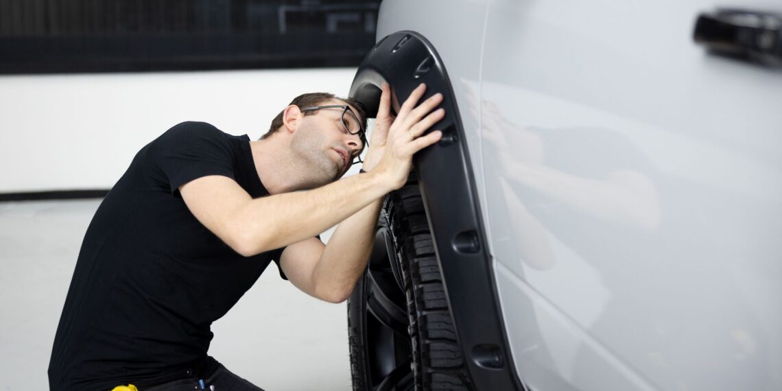 man inspecting a car