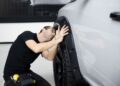 man inspecting a car