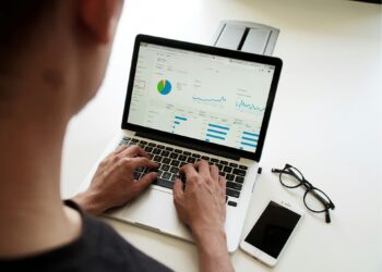 man typing on macbook